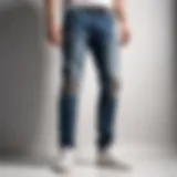 Stylish contrast panel side ripped jeans displayed against a minimalist backdrop