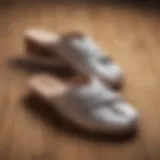 Elegant criss cross slippers on a wooden surface