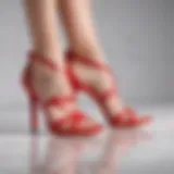 An elegant pair of red strappy shoes displayed on a chic white surface.